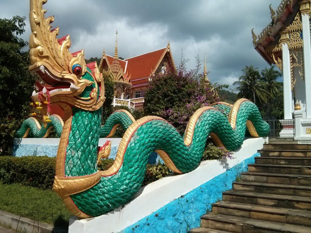 View of dragon sculpture adorning the stairs to one of wat chalongs structures