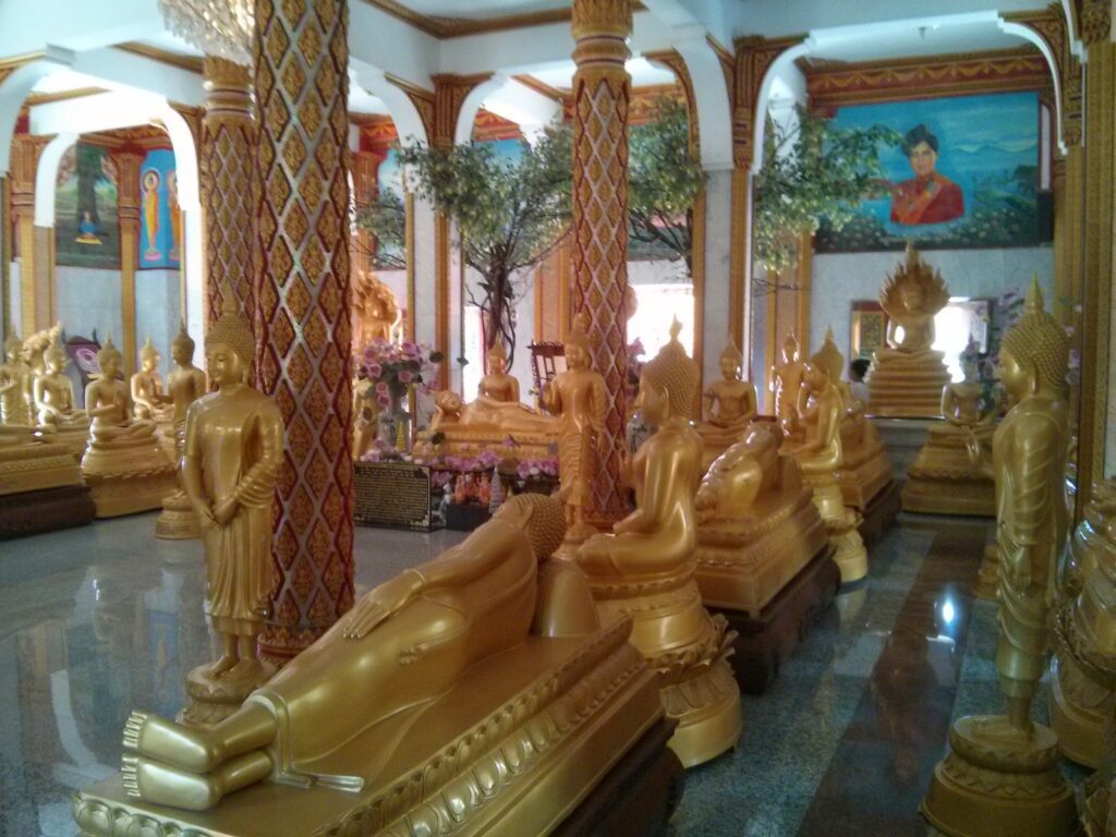 a room full of golden buddha statues inside of wat chalong