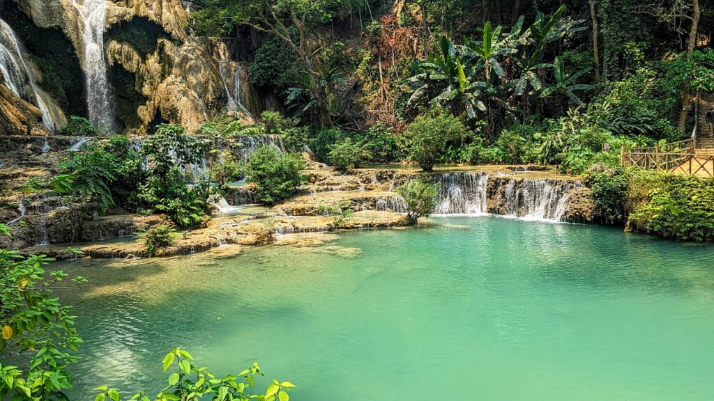 large lagoon style rockpool with small waterfall at kuang si falls