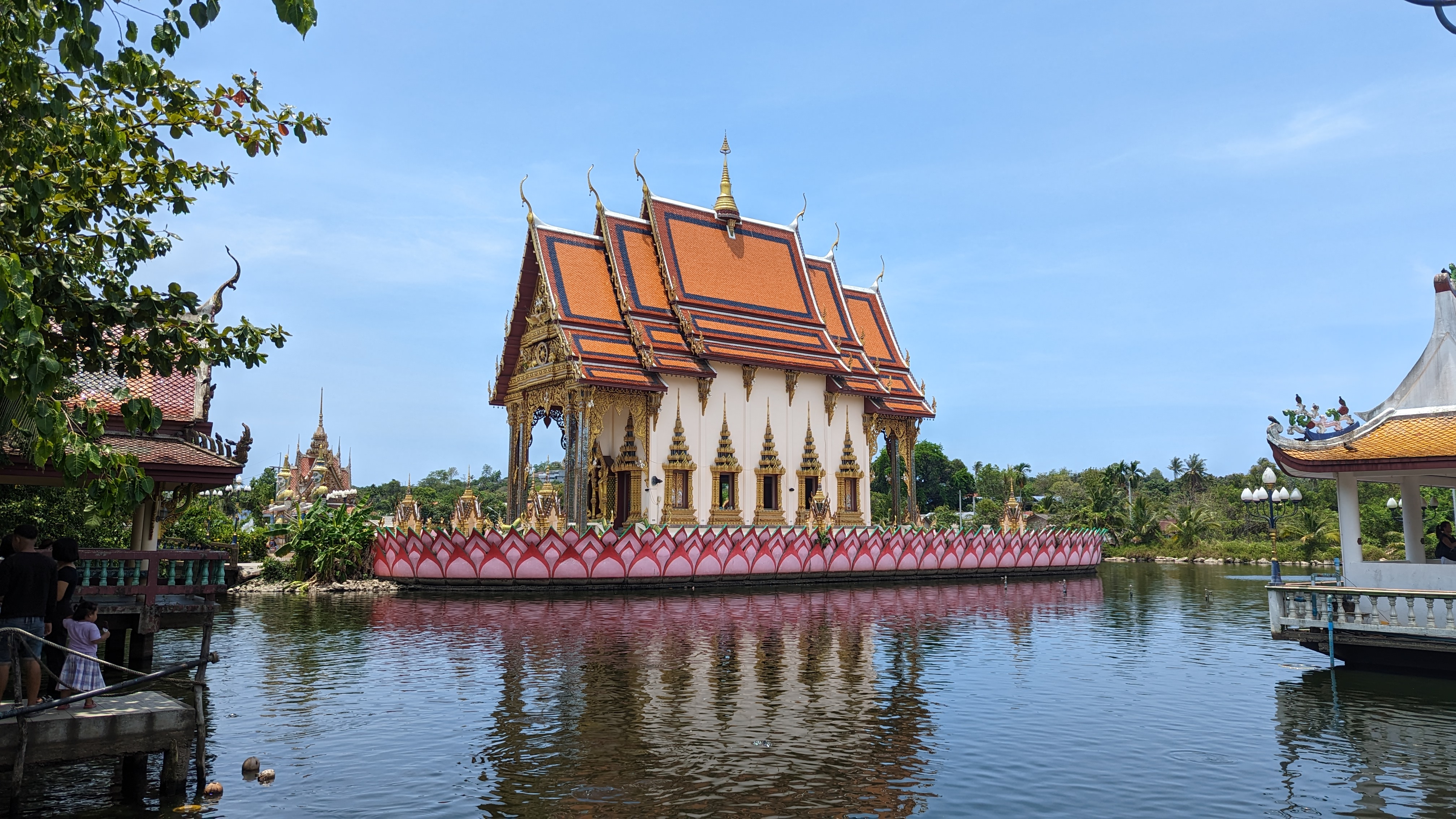 A serene view of Wat Plai Laem, Koh Samui, surrounded by lush greenery and tranquil lotus ponds