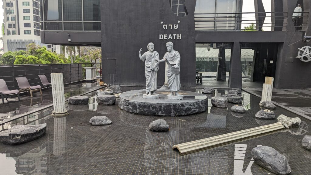 Statues themed from History adorn the rooftop levels of Kid Mai Death cafe