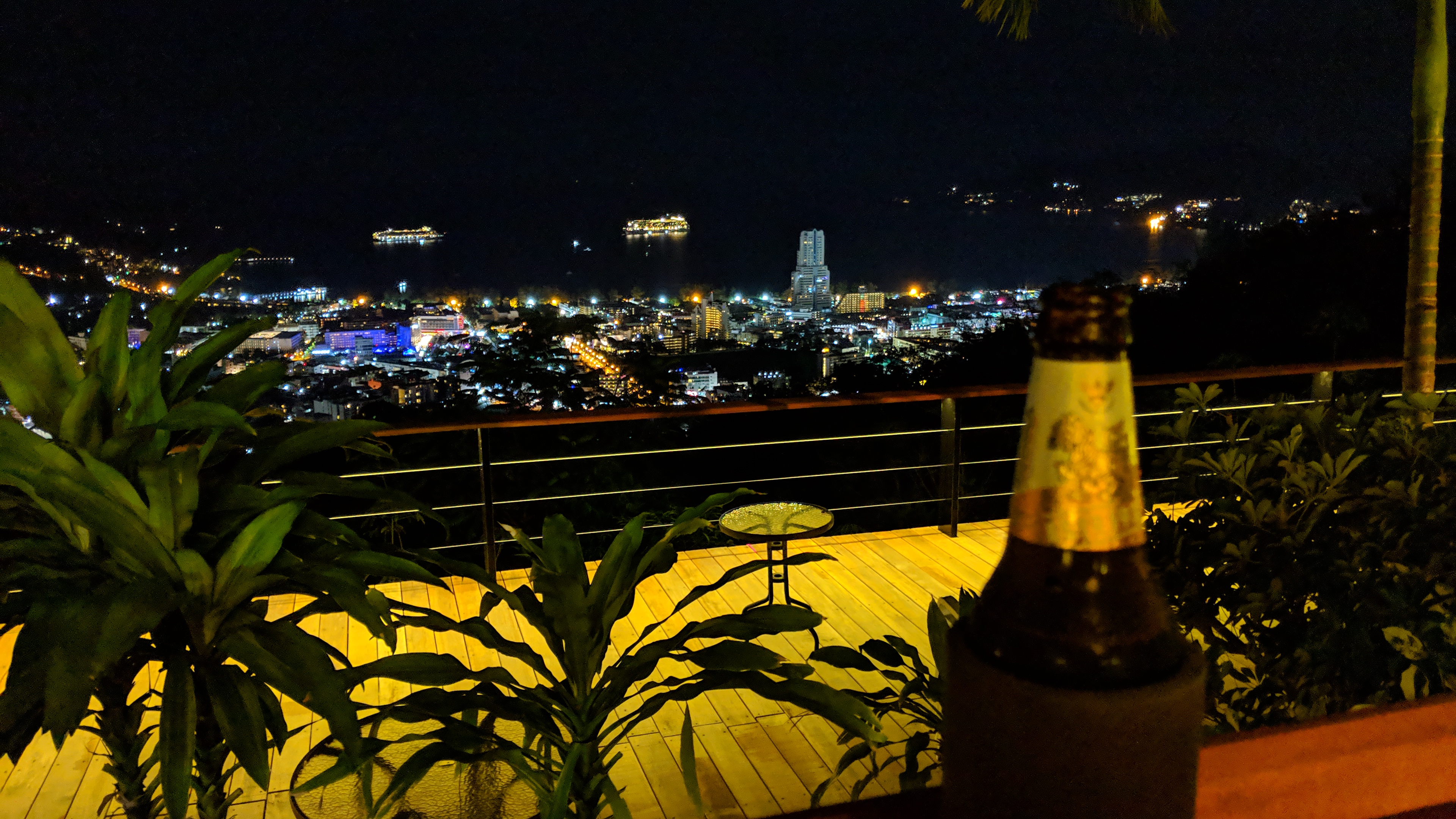 Night View from Patong hill Looking down over Patong and Patong Bay all lit up at night. A singher beer is in the right of frame slightly blurred