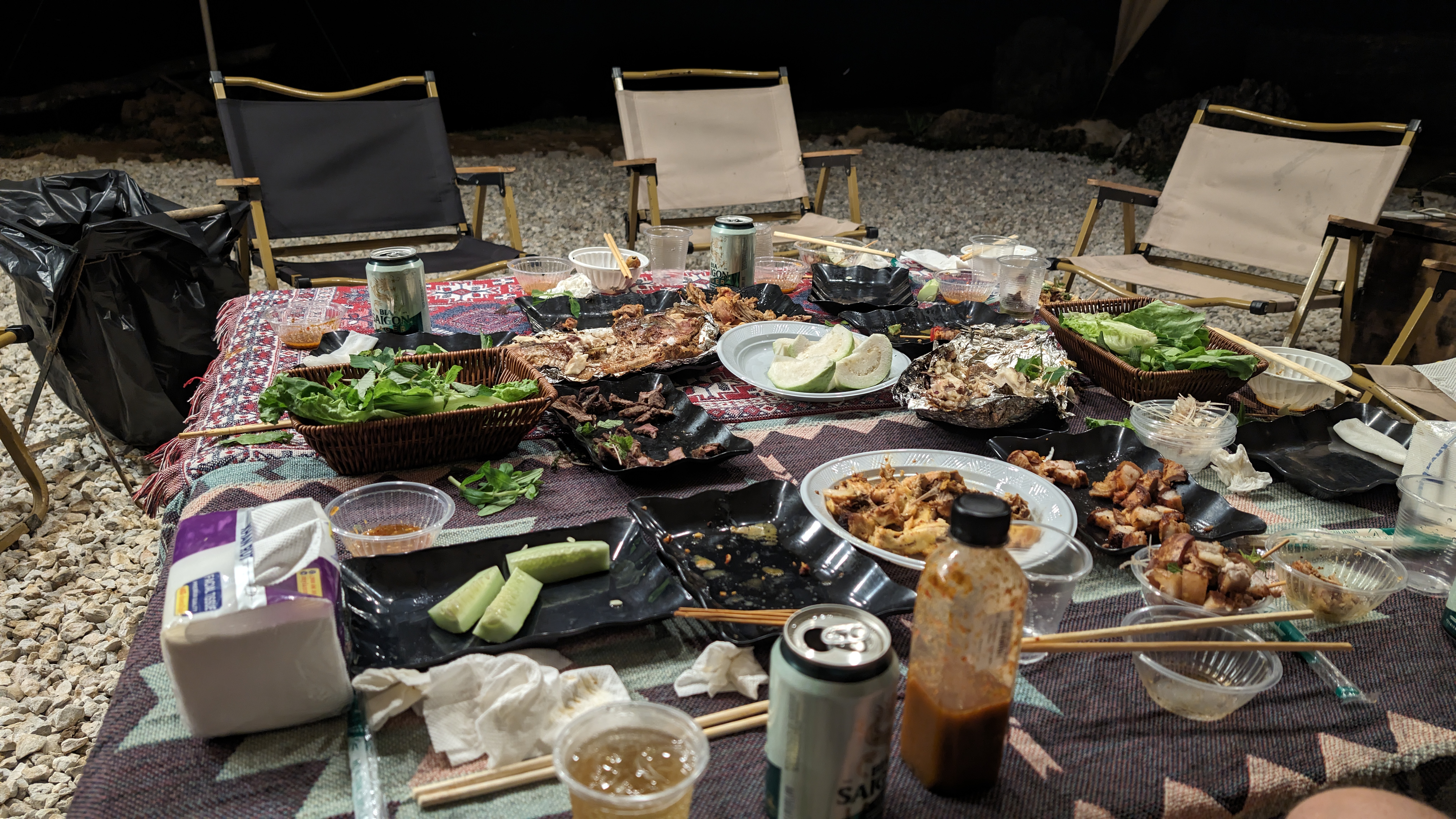 Huge spread of food, numerous dishes on a large table at the Vietnamese campsite, Dat Camping